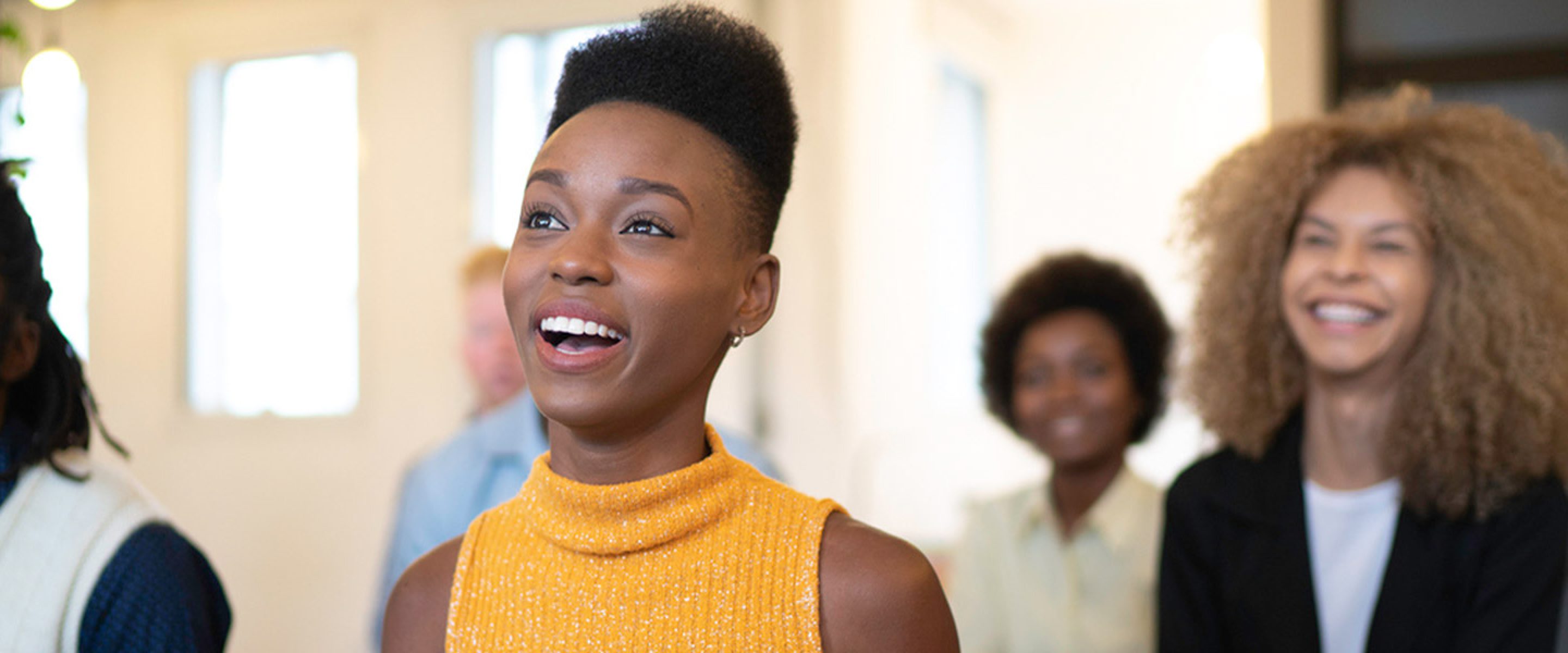 Young professionals smile while listening to a presentation