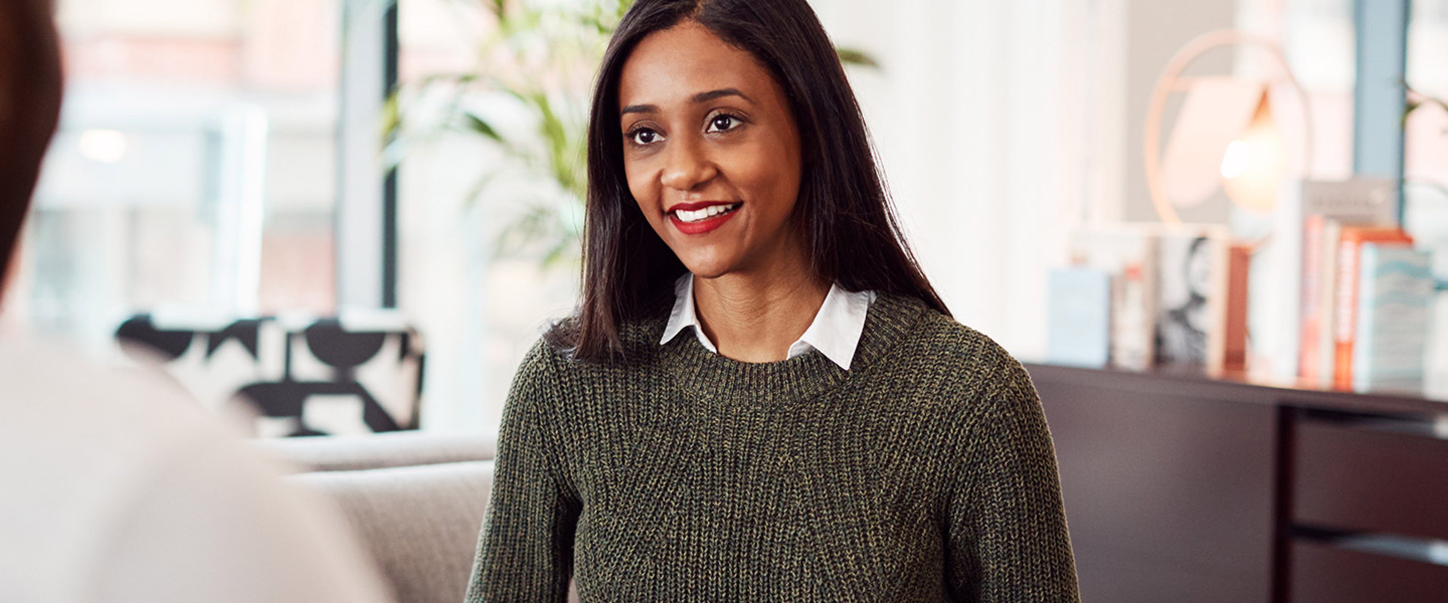 Female business professional meets with a male colleague in her office