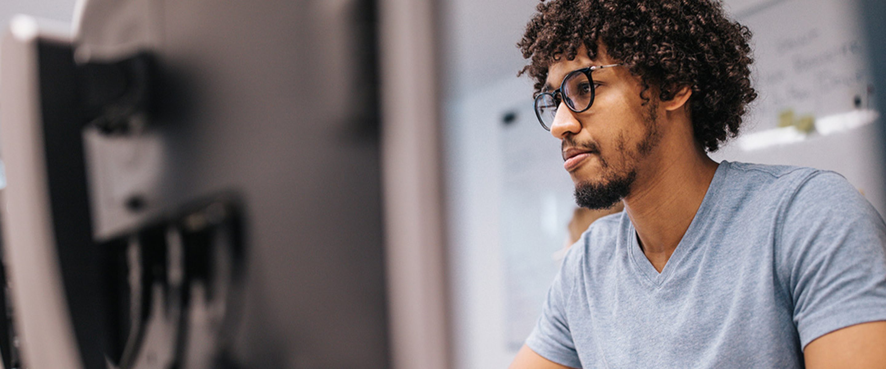 Man wearing glasses uses a computer