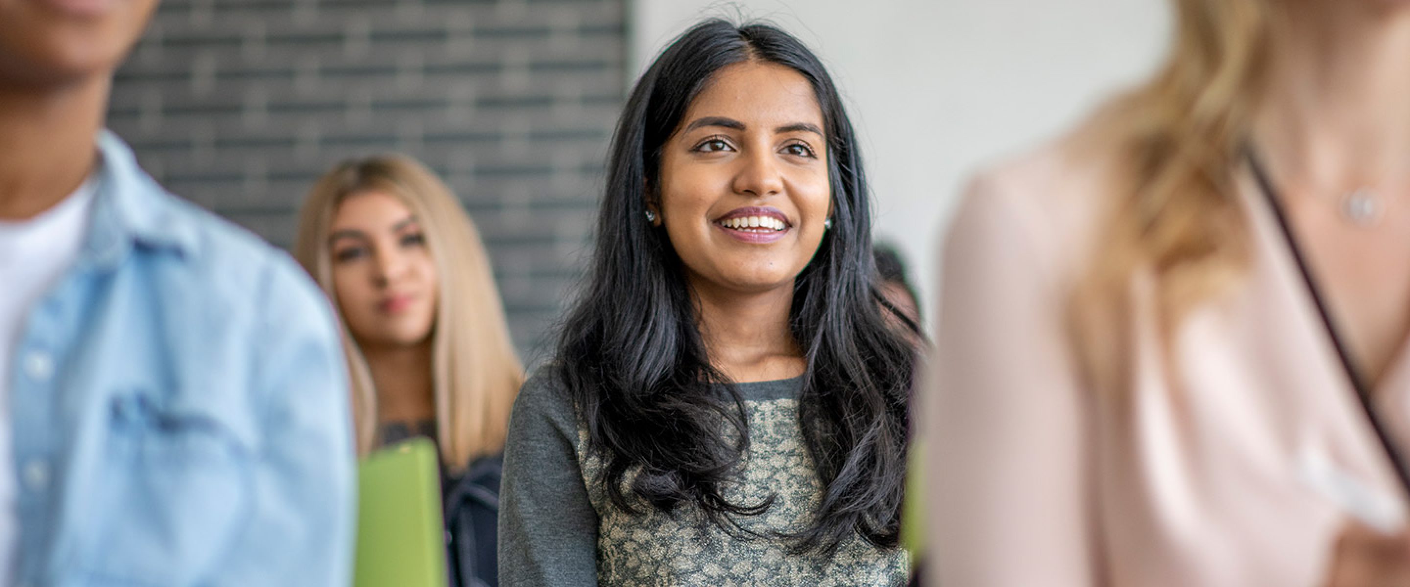 Female student smiles while listening to lecture