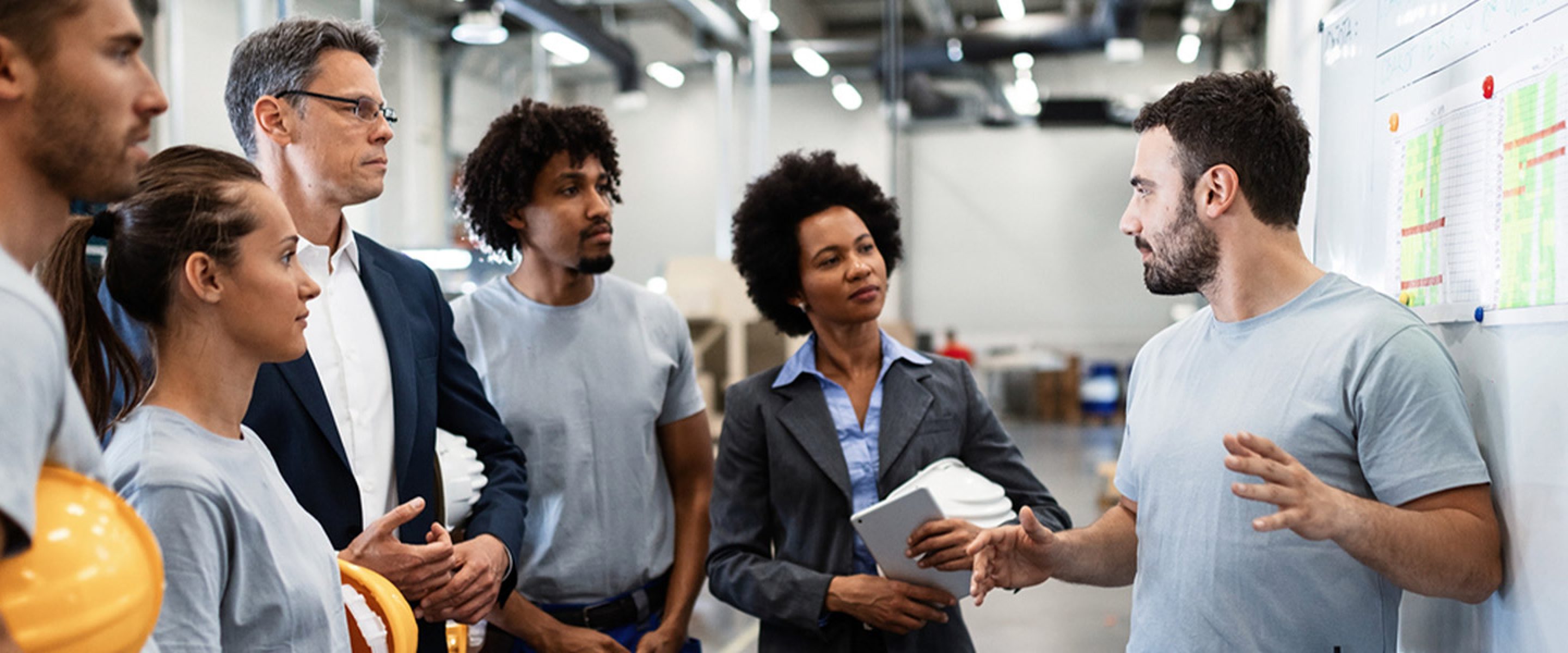 Group of business people and other workers gather for a team meeting
