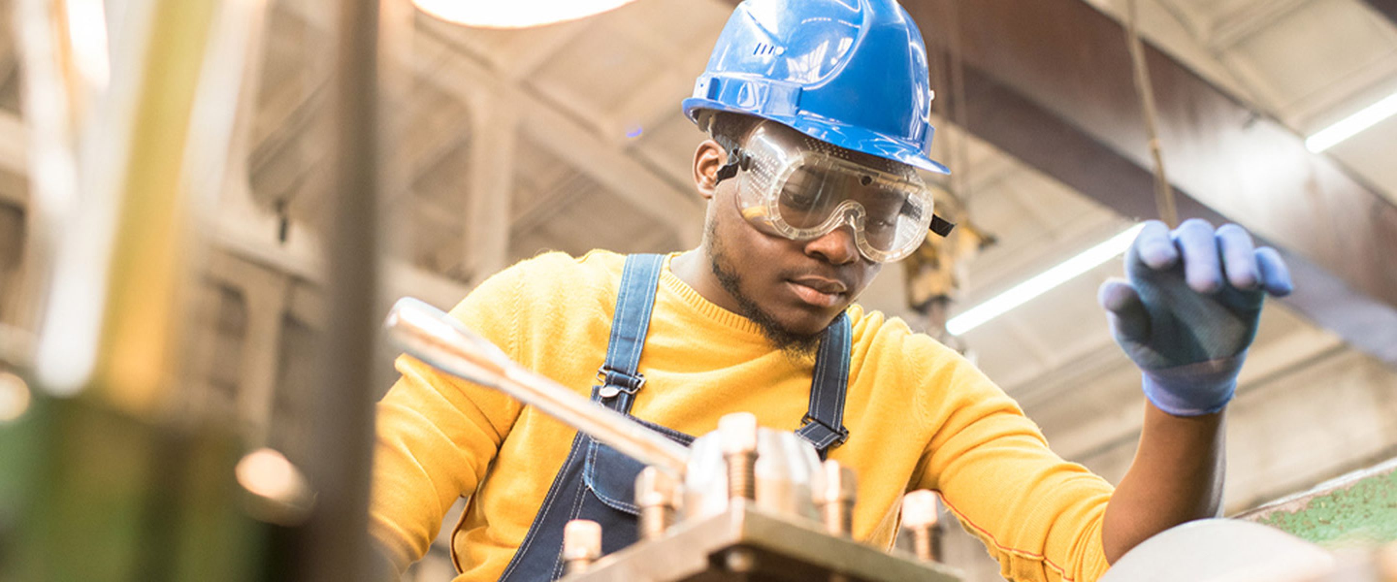 Young male factory worker focuses on task